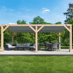Large timber pergola with corrugated roof, outdoor sofa and dining area on concrete patio in lush garden